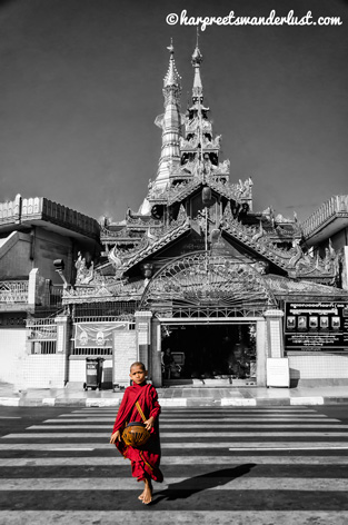 A red robed monk with the Sule Pagoda in the background
