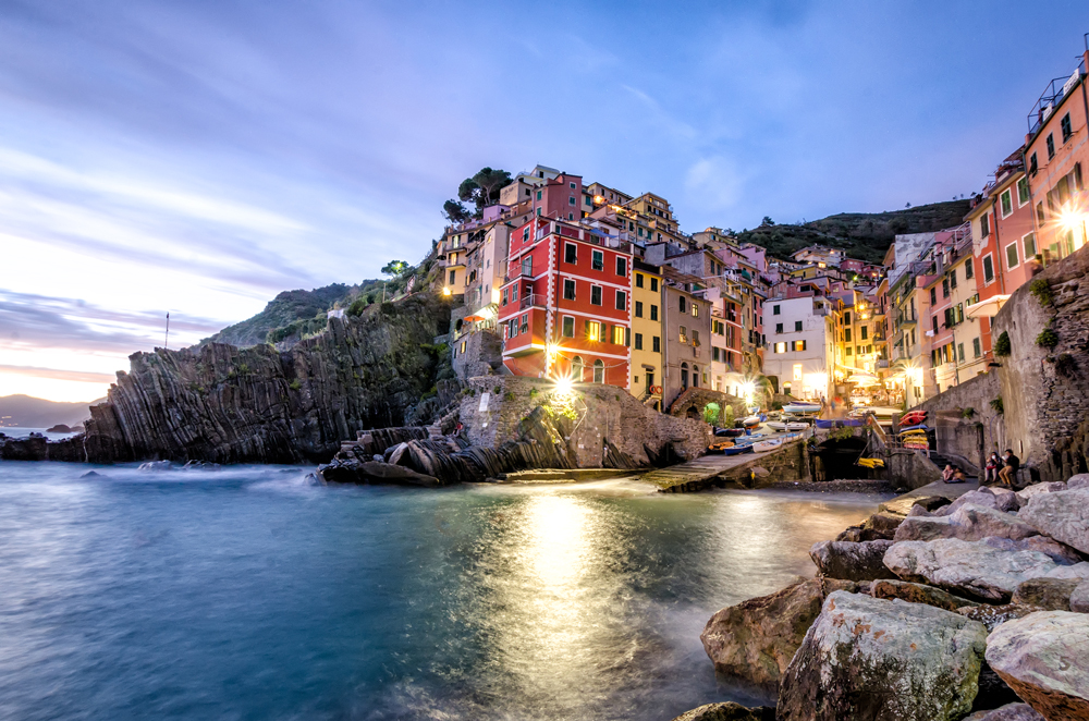 Twinkling lights come on in Riomaggiore at dusk