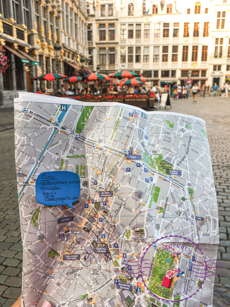 Harpreet holding a map in the middle of Grand Place Brussels for the self guided chocolate tour